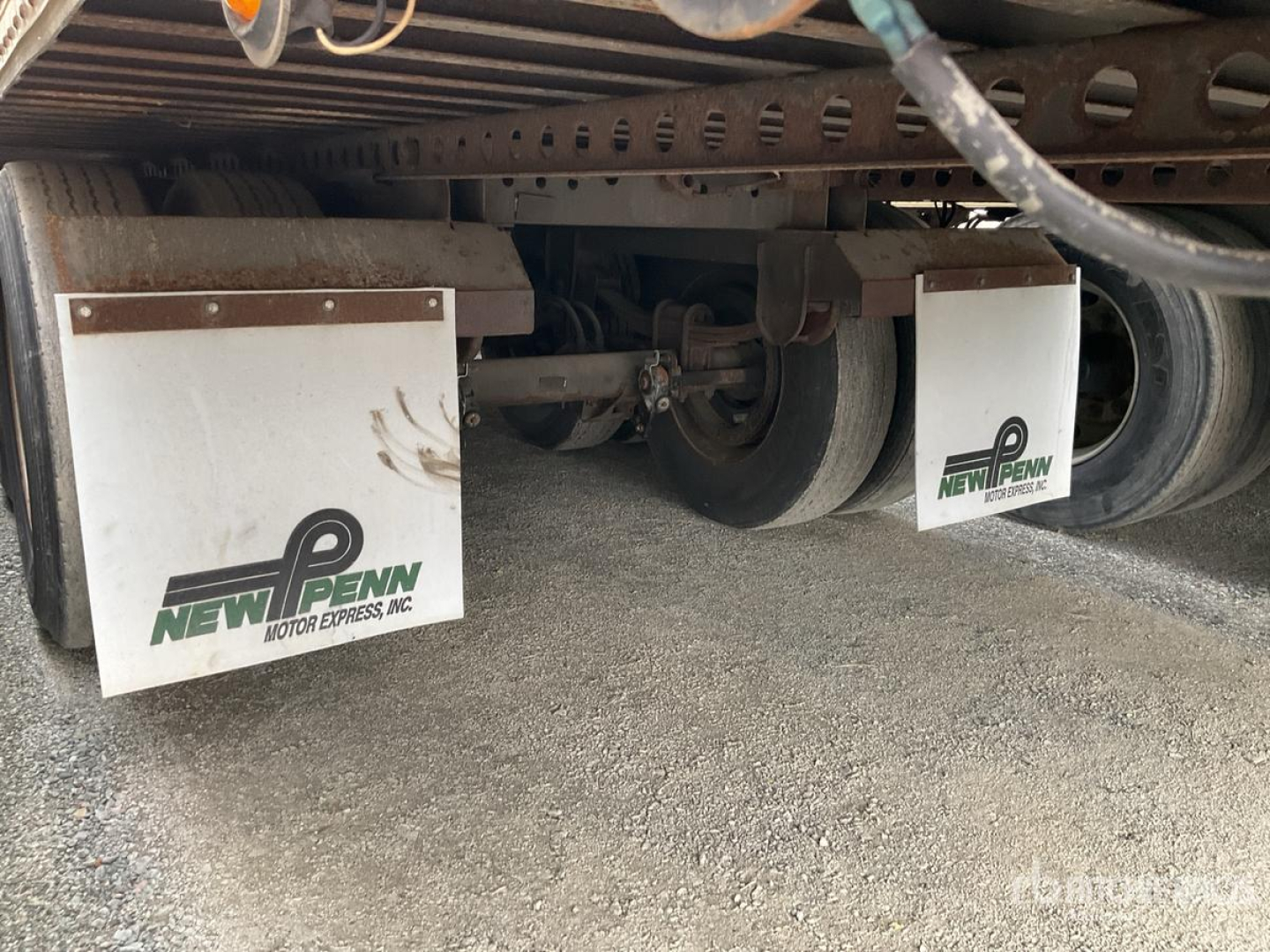 Trailer undercarriage showing New Penn Mud Flaps and wheel axles beneath a 2003 Wabash DVCVHPC trailer.