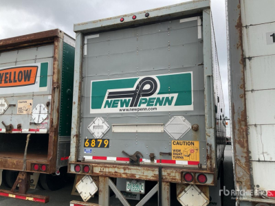 Rear view of a used trailer showing New Penn logo and hazard placards, metal doors with grey paint, license plate area, and reflective tape.