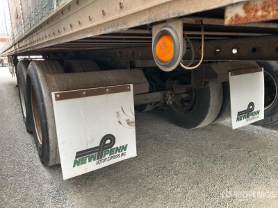 Trailer undercarriage with dual rear axles, mud flaps labeled 'New Penn Motor Express, Inc.' and a circular orange reflector; van trailer with wheel wells and undercarriage components visible.