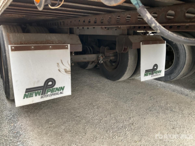 Trailer undercarriage showing New Penn Mud Flaps and wheel axles beneath a 2003 Wabash DVCVHPC trailer.