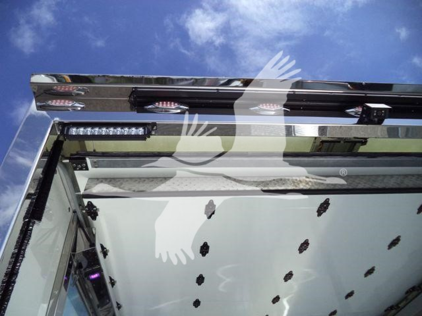Truck rollback bed area with hydraulic components and rear lighting assembly visible; no legible text clearly readable on labels in the image.