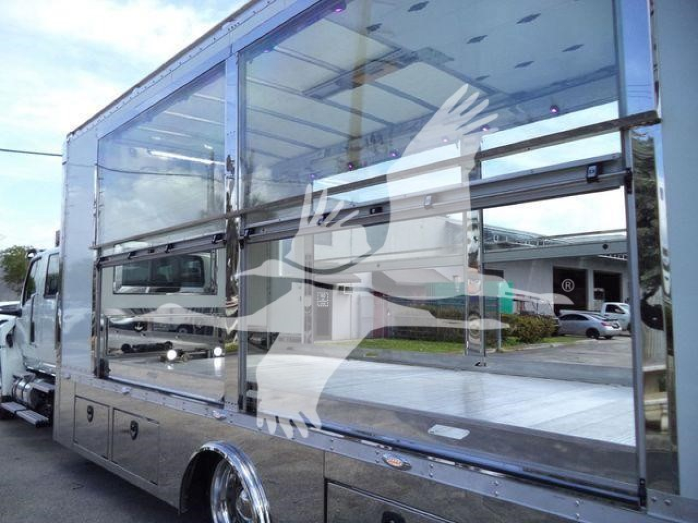 Truck body with large glass windows showing aluminum frame and side compartment doors.