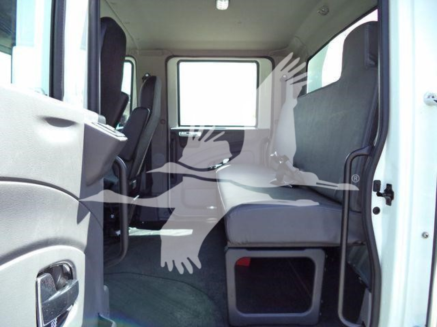 Interior cab view of a 2027 International MV rollback truck showing front passenger seat and middle seating area with window and minimal dashboard.