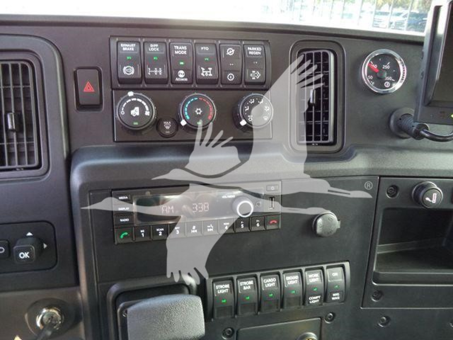 Cockpit of a 2027 International MV truck showing dashboard controls, climate dials, and infotainment panel.