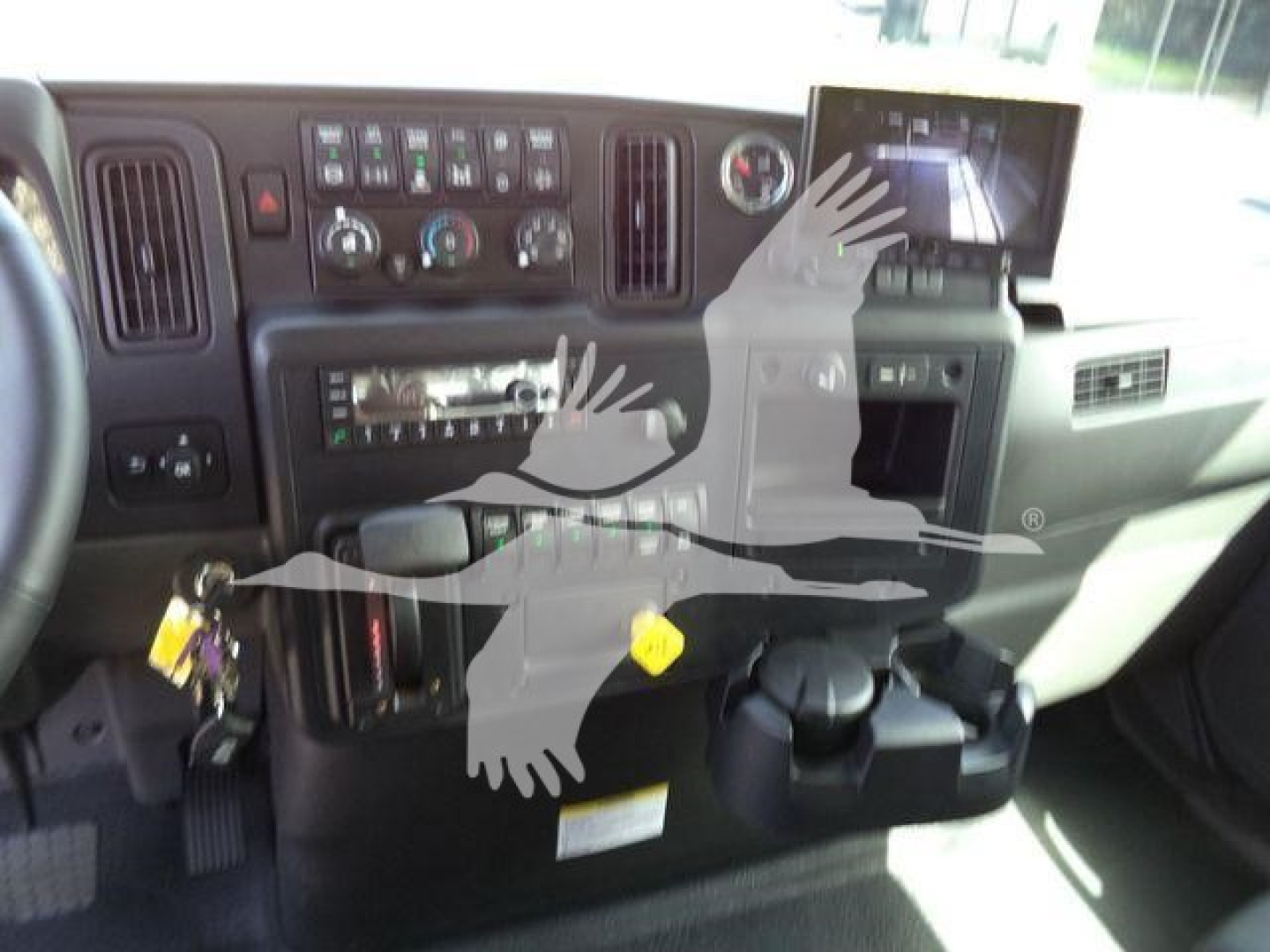 Dashboard of a truck cab showing control panels, radio, climate controls, and a monitor on the right. Various switches and gauges visible.