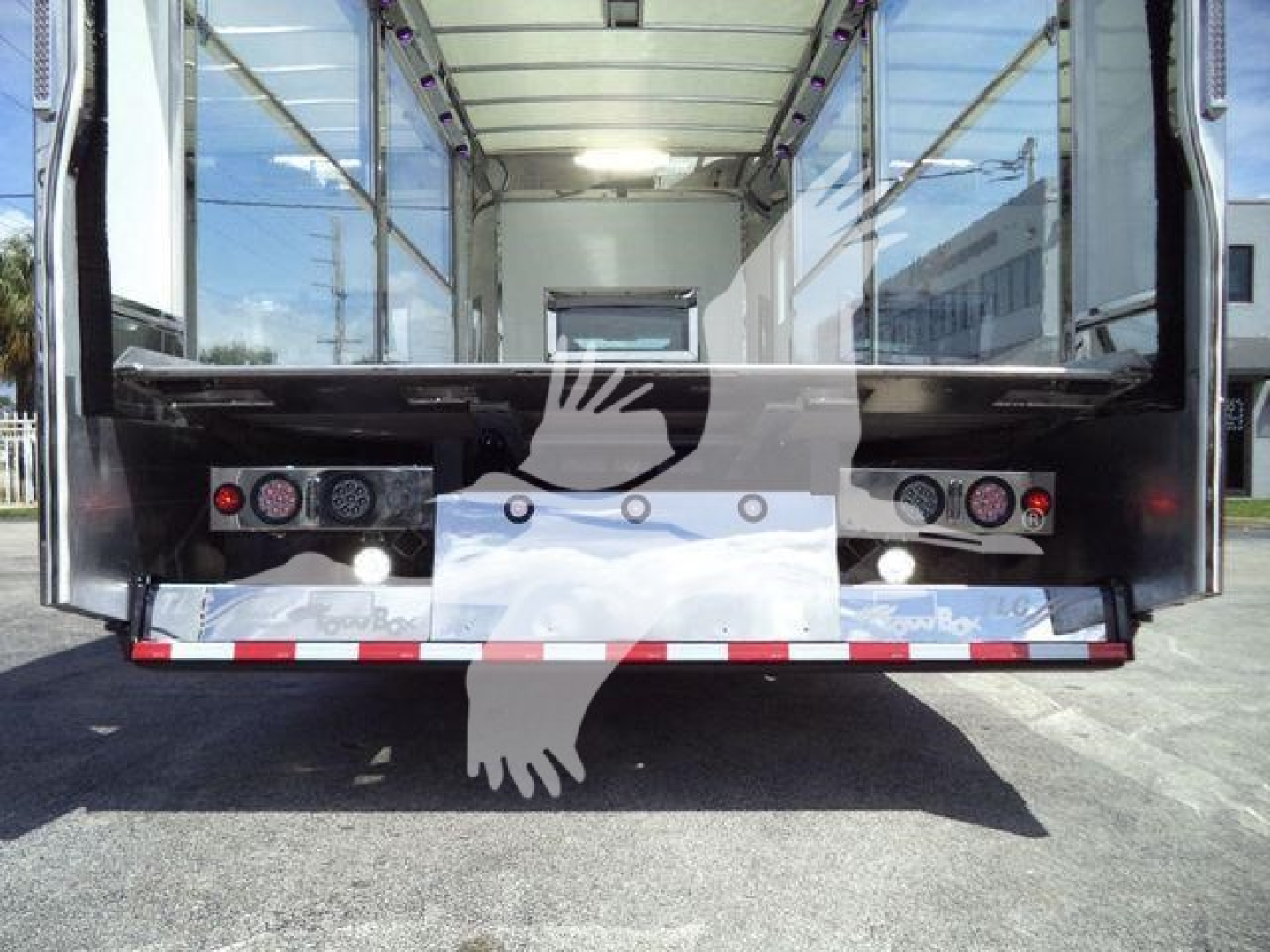 Rear view of a new International MV rollback truck showing open cargo area and rear bumper with lights.