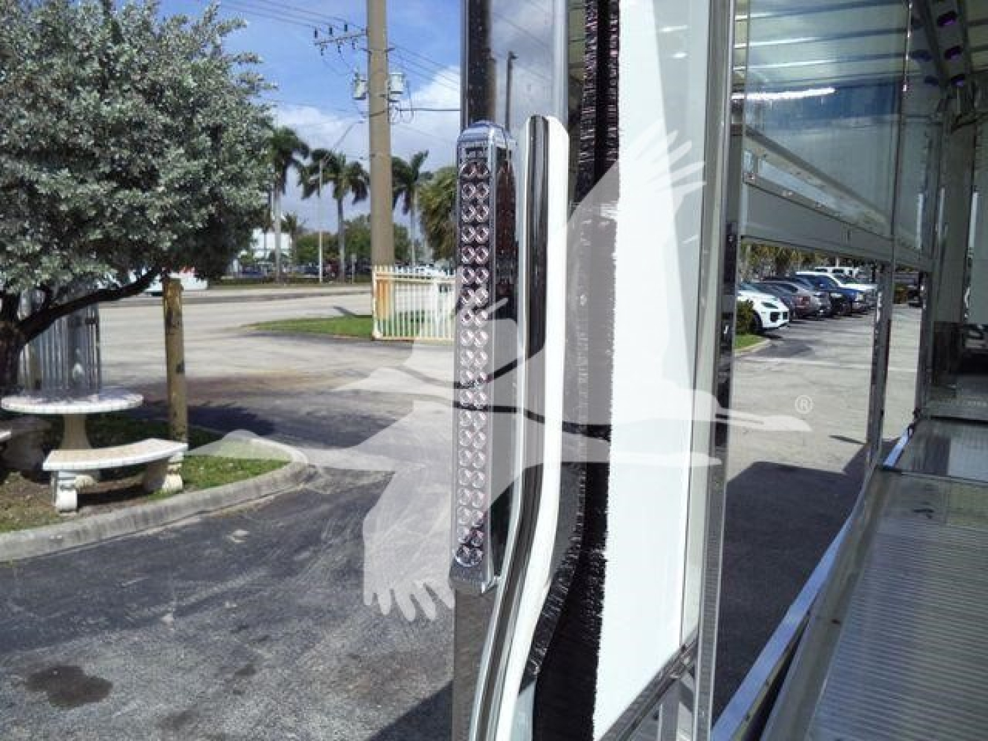 International truck rollback body side with chrome steps and side door open, front cab reflection in glass.
