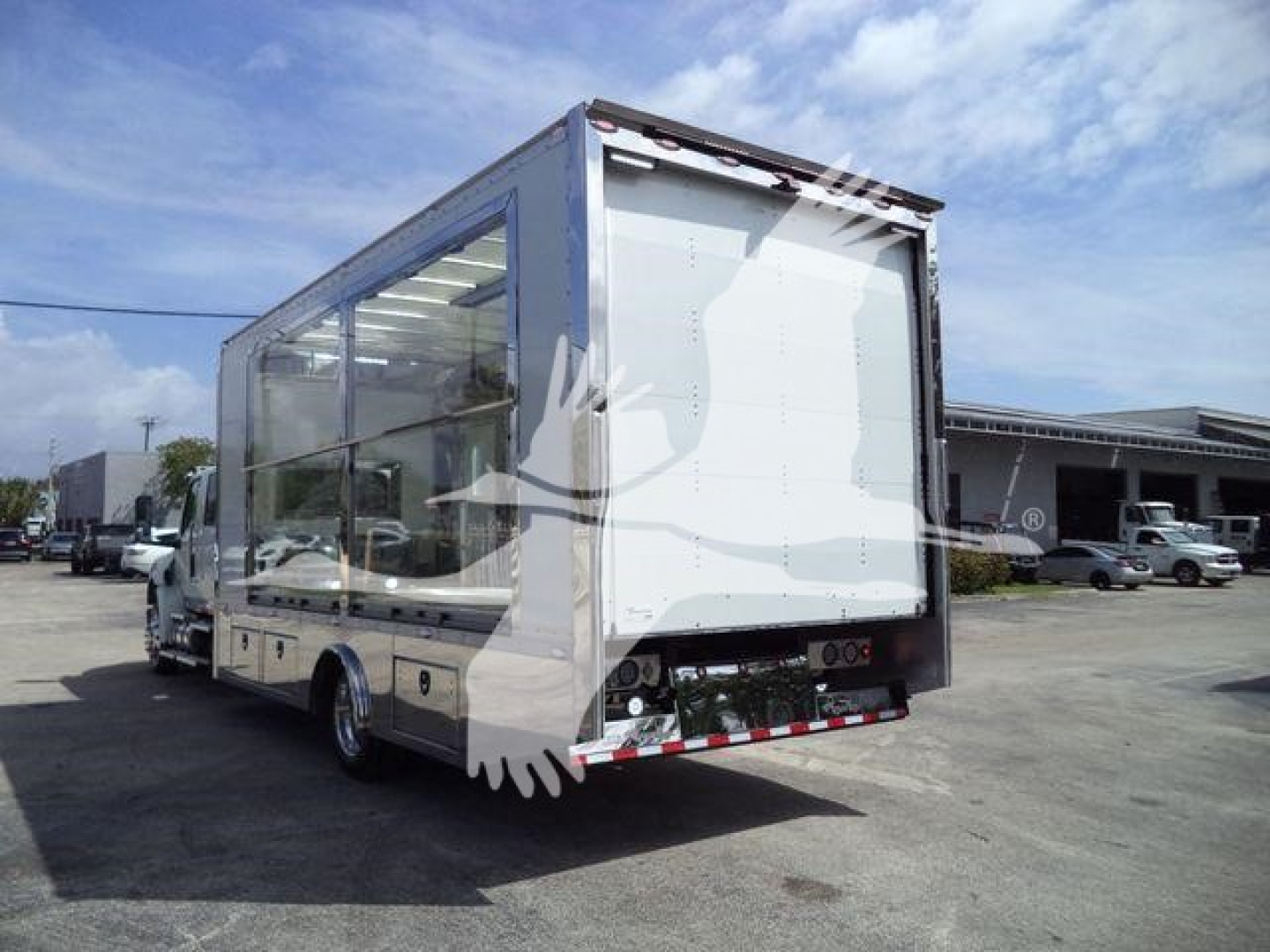 Truck body showing a large glass-sided rollback unit with transparent walls and rear loading ramp.