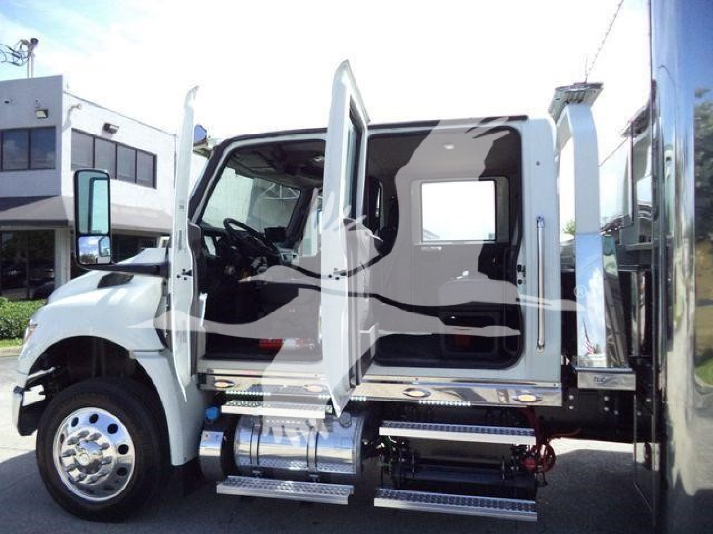 Truck cab interior and side steps of a 2027 International MV rollback truck with doors open.