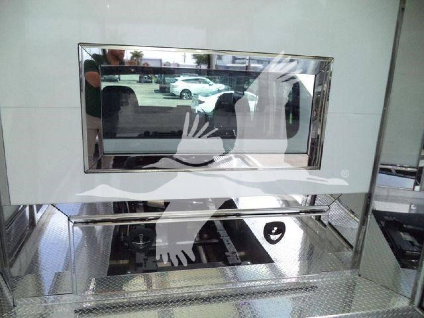Truck equipment image showing a chrome-framed monitor and reflective interior surfaces.