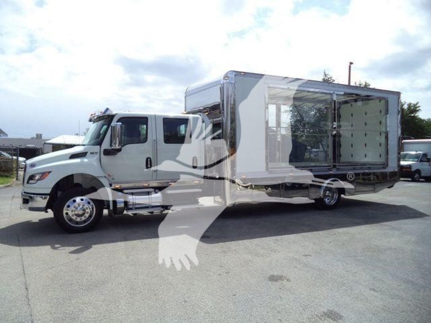 Truck with a large box body attached to a cab-over engine; side view showing loading area doors open.