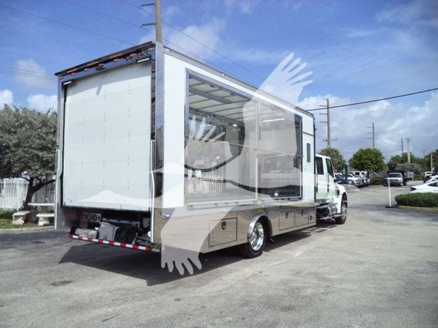 Truck body on a white International MV rollback truck showing a large cargo box and rear liftgate.