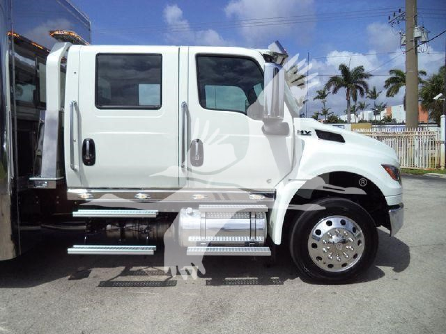 White 2027 International MV rollback truck side view showing cab and chrome steps