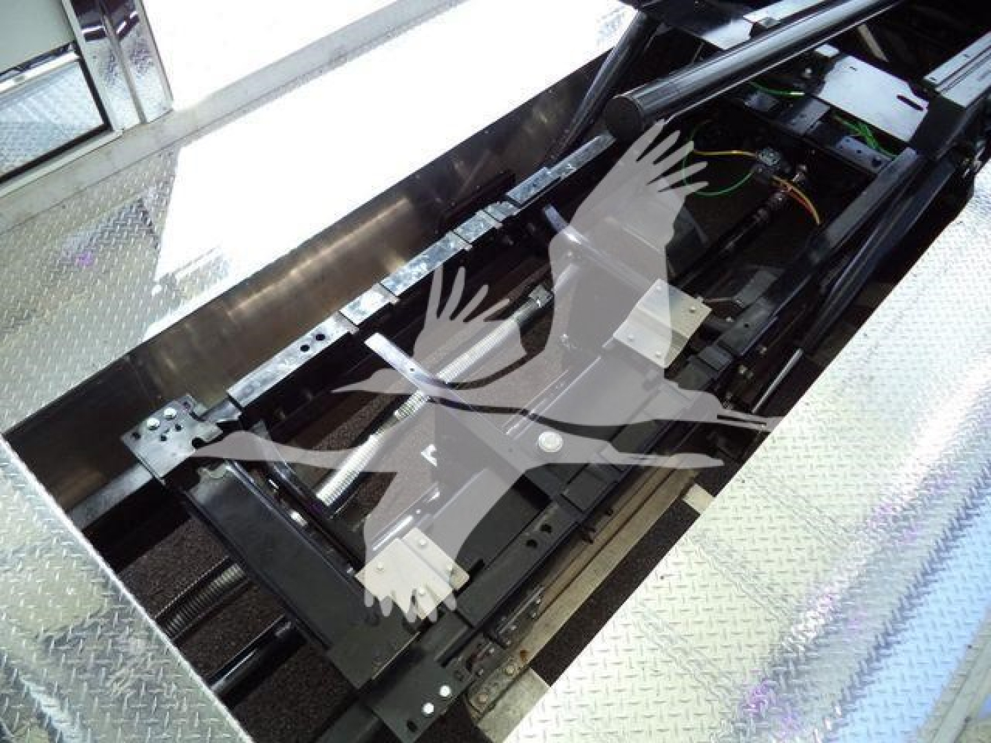 Truck undercarriage view showing frame and components with green and orange wiring visible.