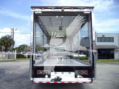 Back of new 2027 International MV rollback truck body showing empty aluminum cargo bed and rear doors.