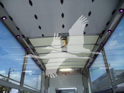 Trucks rollback bed interior showing ceiling panels and LED purple light strips, view from rear with open sides.