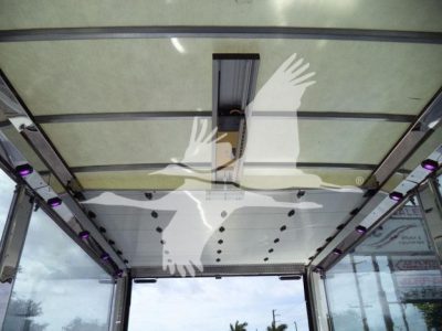 Interior of a rollback truck cargo area with light panels and ceiling-mounted walkway, showing a narrow doorway and purple LEDs along the sides.