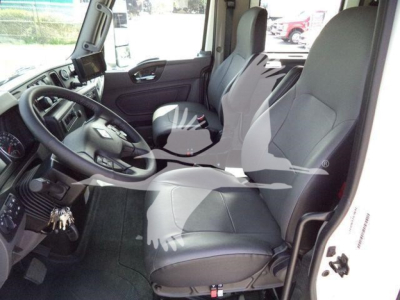 Truck cab interior showing driver and passenger seats, steering wheel, and dashboard of a new International MV rollback truck.