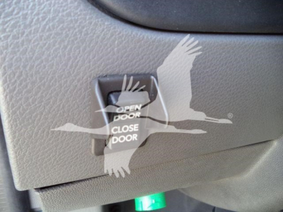 Close-up of interior switch panel showing Open Door / Close Door label located on a gray textured surface inside a 2027 International MV rollback truck.