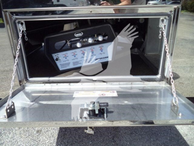 Truck equipment showing a control panel with gauges and switches mounted inside a storage compartment.
