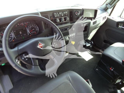 Truck cab interior showing steering wheel, dashboard gauges, and center console of a new 2027 International MV rollback truck.