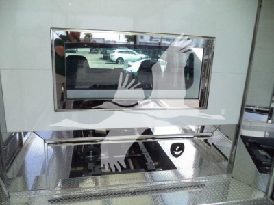 Truck equipment image showing a chrome-framed monitor and reflective interior surfaces.