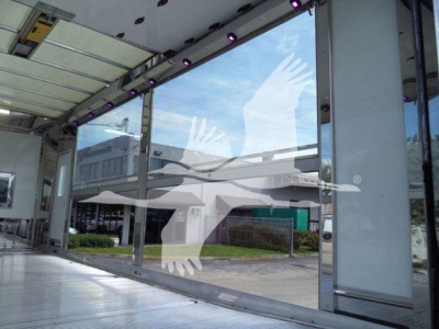 Truck showroom photos with large glass doors and reflection, showing a roll-back truck bay interior.