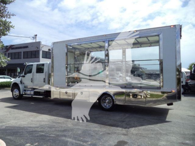 Truck-mounted mobile showroom or trailer with large glass windows, International MV cab chassis, chrome undercarriage, side entry, rollback category truck.