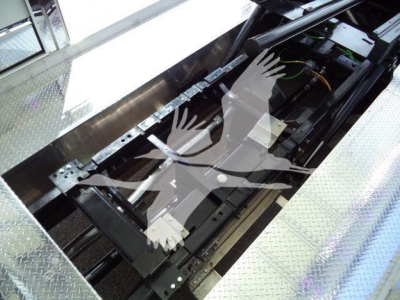 Truck undercarriage view showing frame and components with green and orange wiring visible.