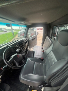 Kenworth T280 cab interior showing driver seat, bench passenger seat, steering wheel, and dashboard with door open.
