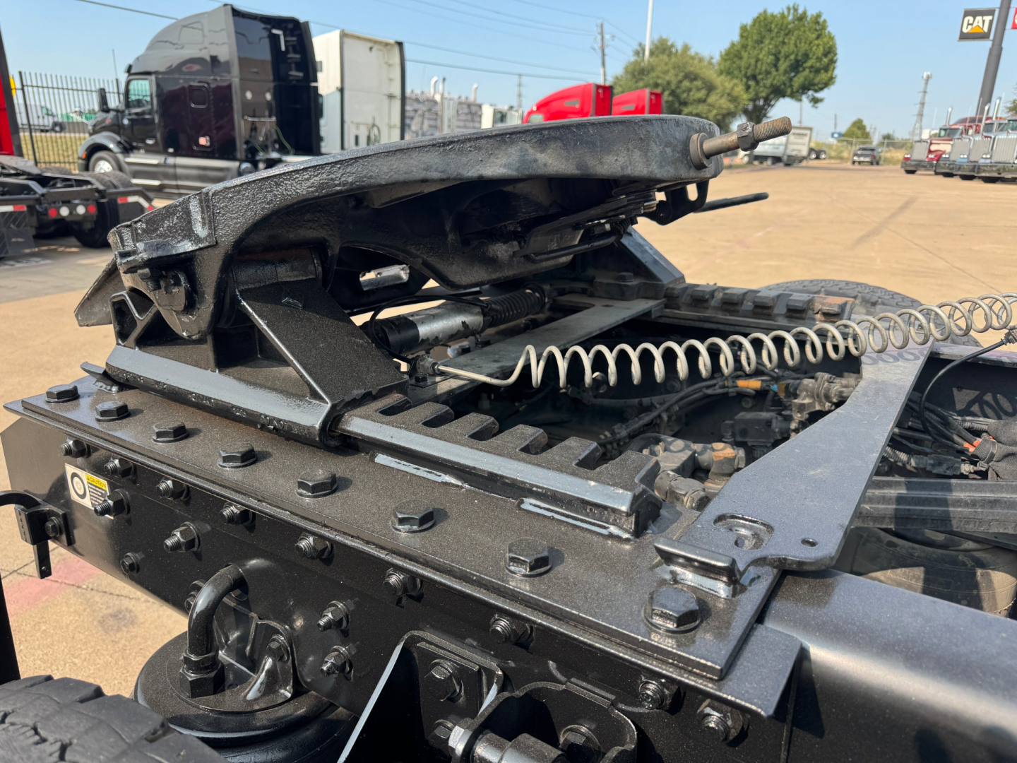 Kenworth T880 tractor chassis close-up showing air ride system and suspension components with metal brackets and coil spring.