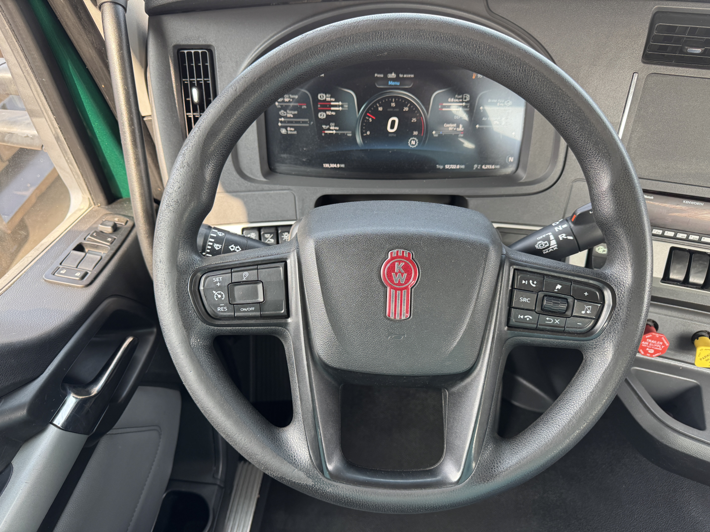 Steering wheel and dashboard of a Kenworth T880 cab showing instrument cluster and steering wheel controls.