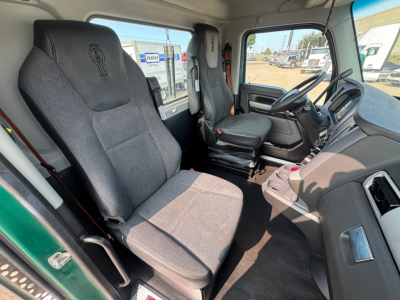 Interior of a 2022 Kenworth T880 cab showing driver seat, passenger seat, steering wheel, and dashboard in view.