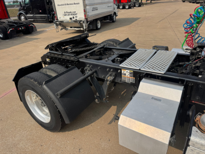 Kenworth T880 tractor rear chassis showing fifth wheel mount and air lines with aluminum toolbox and steps.