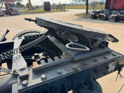 Trailer kingpin area of a Kenworth T880 truck showing mounting platform and air lines with metal brackets and bolts.