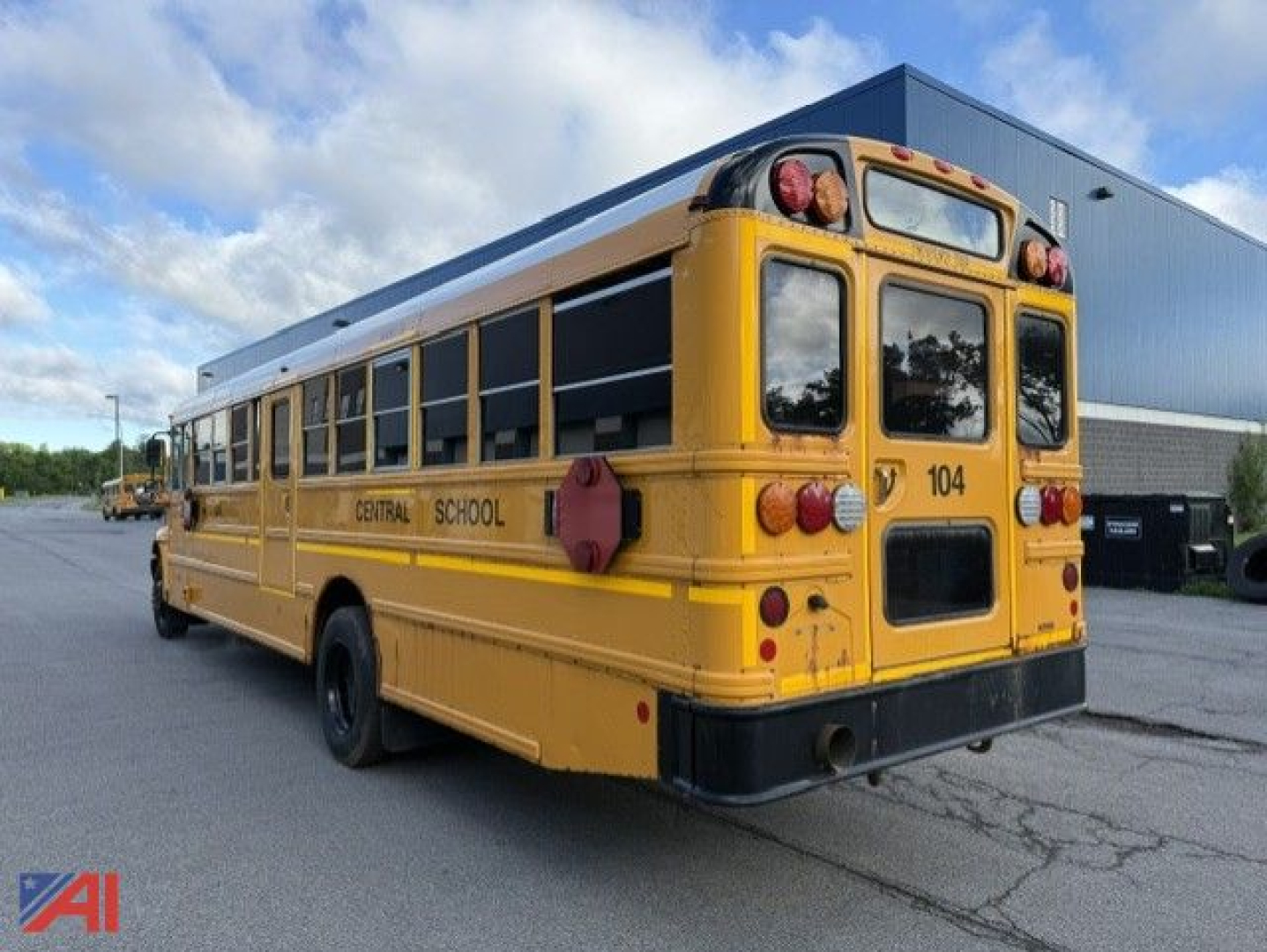 School bus rear angle view showing yellow body and safety lights, 'CENTRAL SCHOOL' lettering, back doors, and bus number 104.