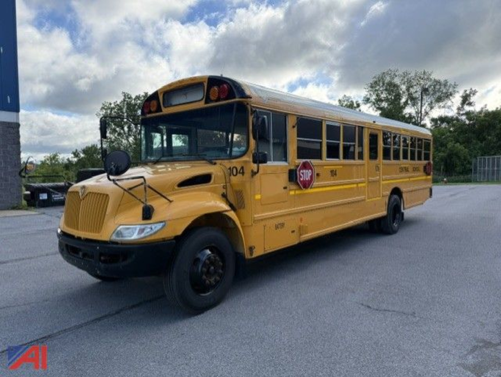 School bus front-left view with yellow exterior, stop sign, and hood scoop; bus number 104 visible.