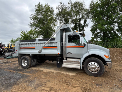 Kenworth T380 dump truck side view showing dump body with orange/black stripes and chrome steps.