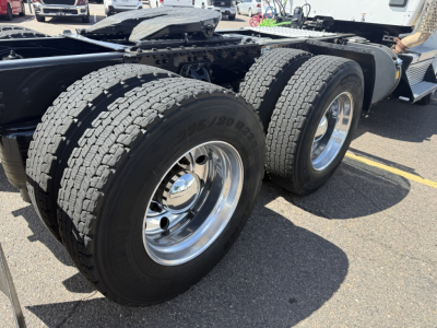 Kenworth T880 chassis with dual rear axles and large tires, chrome wheels, visible wheel wells and frame, side view.