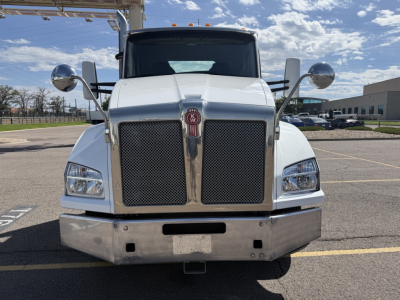 Front view of a white 2020 Kenworth T880 conventional daycab truck showing large black grille, chrome bumper, and round side mirrors.
