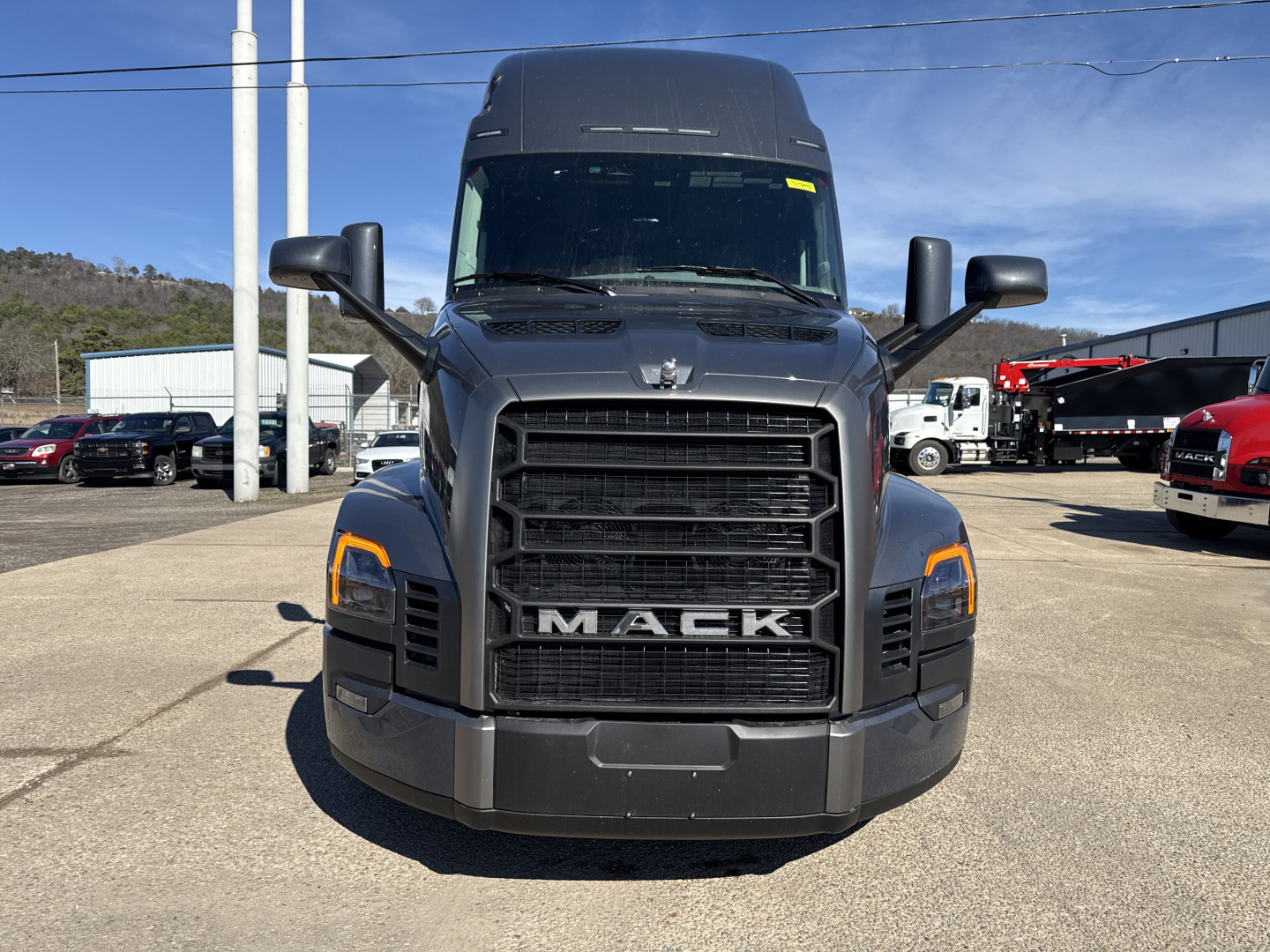 Front view of a new 2026 Mack PR64T76H conventional sleeper truck showing large grille with MACK badge, headlights, and bumper.
