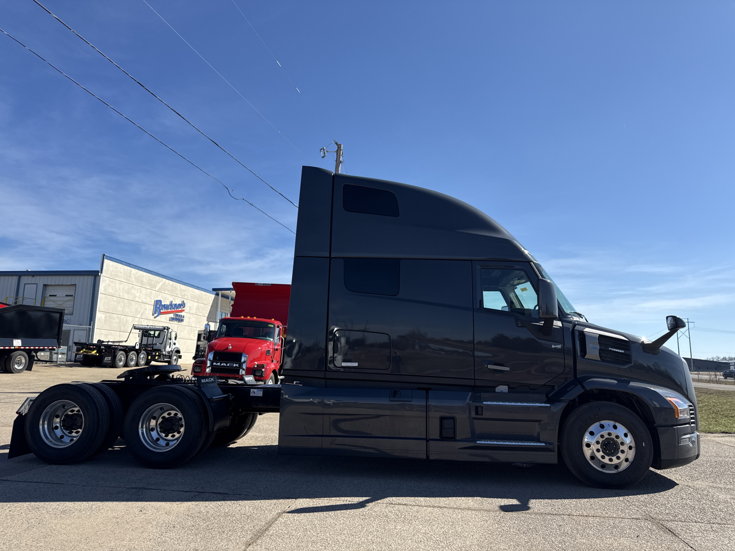 2026 Mack PR64T76H tractor cab side view showing sleeper, chassis, and dual rear axles with black paint.