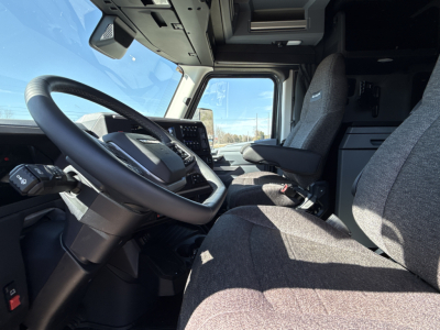 Cab interior of a 2026 Mack PR64T76H truck showing driver seat, steering wheel, dashboard, and passenger seat