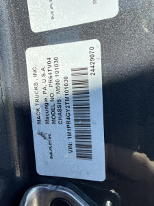 Mack Trucks label on vehicle door shows VIN 1MPR4GY2TM101030, stock 71740, model PAC- MACK TRUCKS INC, tag details and barcode.