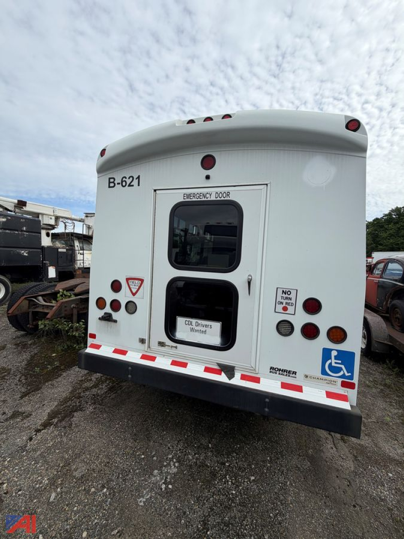 Ford E450 bus rear showing emergency exit doors, handicap placard, B-621 number, and various tail lights.