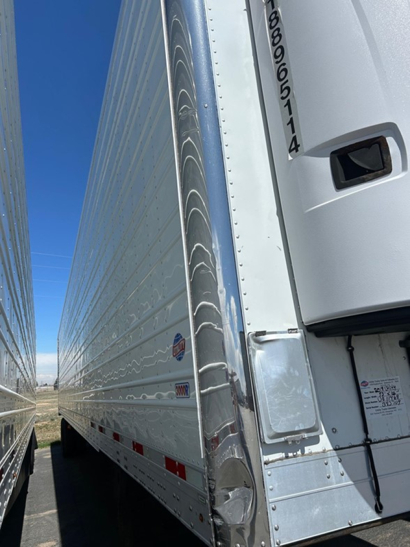 Trailer side with vertical rear corner showing 2018 Utility 3000R W, reefer trailer, aluminum side, reflective stripes, and access panel near front. Visible text includes VIN/ID near door and serial sticker on trailer front corner.