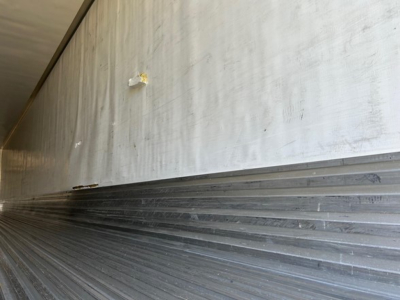 Trailer interior side wall showing corrugated metal surface and transfer from light to shadow, utility reefer trailer section.