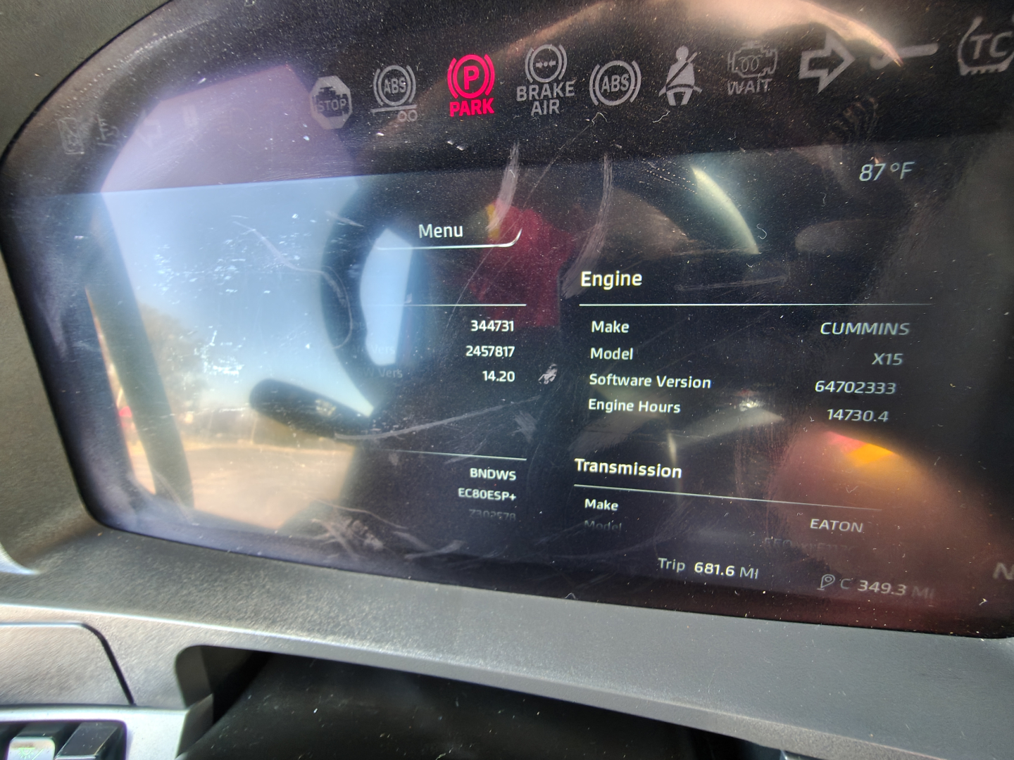 Kenworth T680 dashboard display showing engine information: Make CUMMINS, Model X15, Software Version 64702333, Engine Hours 14730.4, Transmission Make EATON, Trip 50.1 MI, VIN 1XKYD49X0RJ344731 on screen.