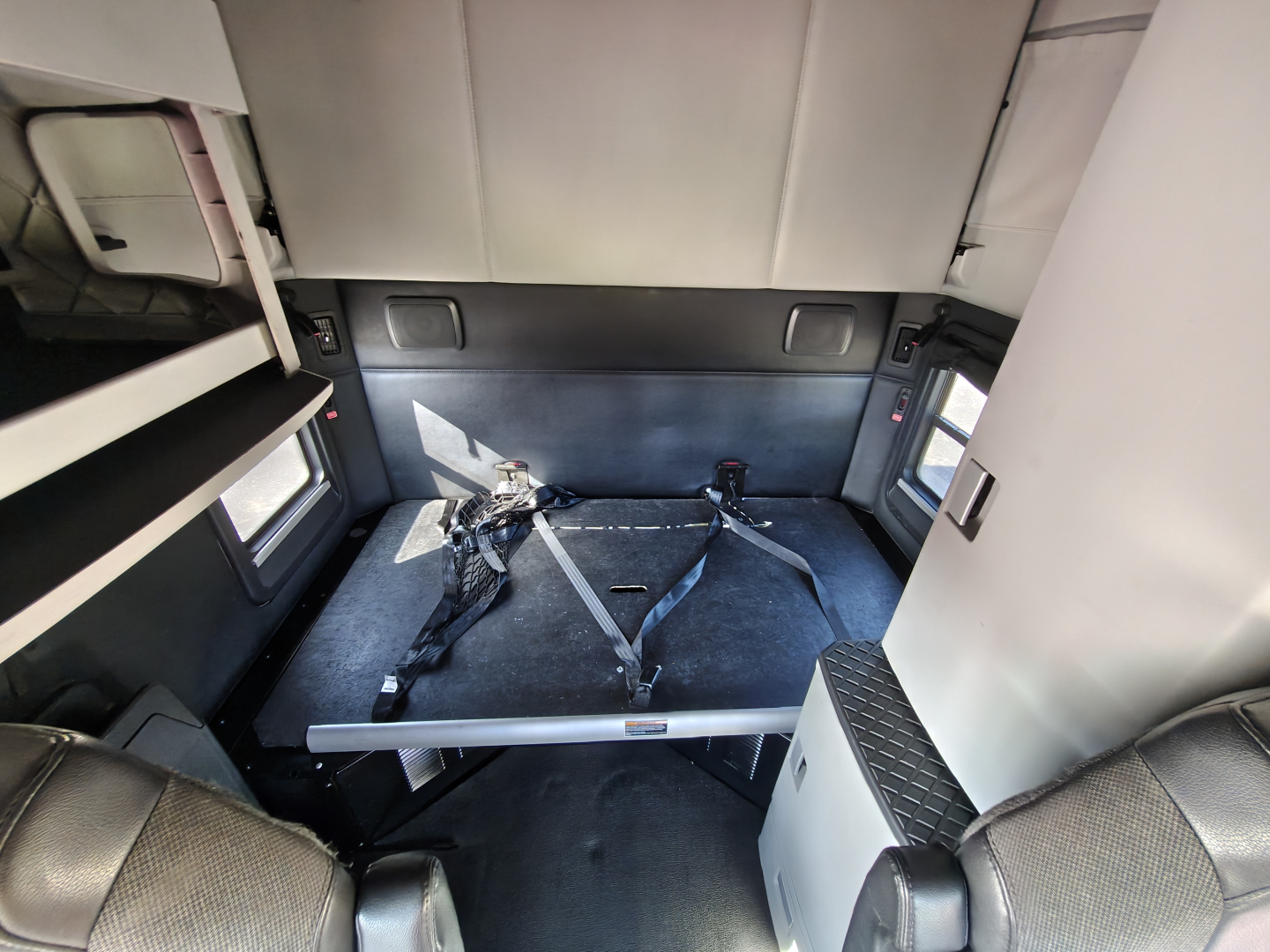 Kenworth T680 sleeper cab interior showing cargo straps and bed area