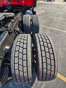 Kenworth T680 rear axles showing dual tires and suspension components. Visible tread pattern on four tires and chassis framing.